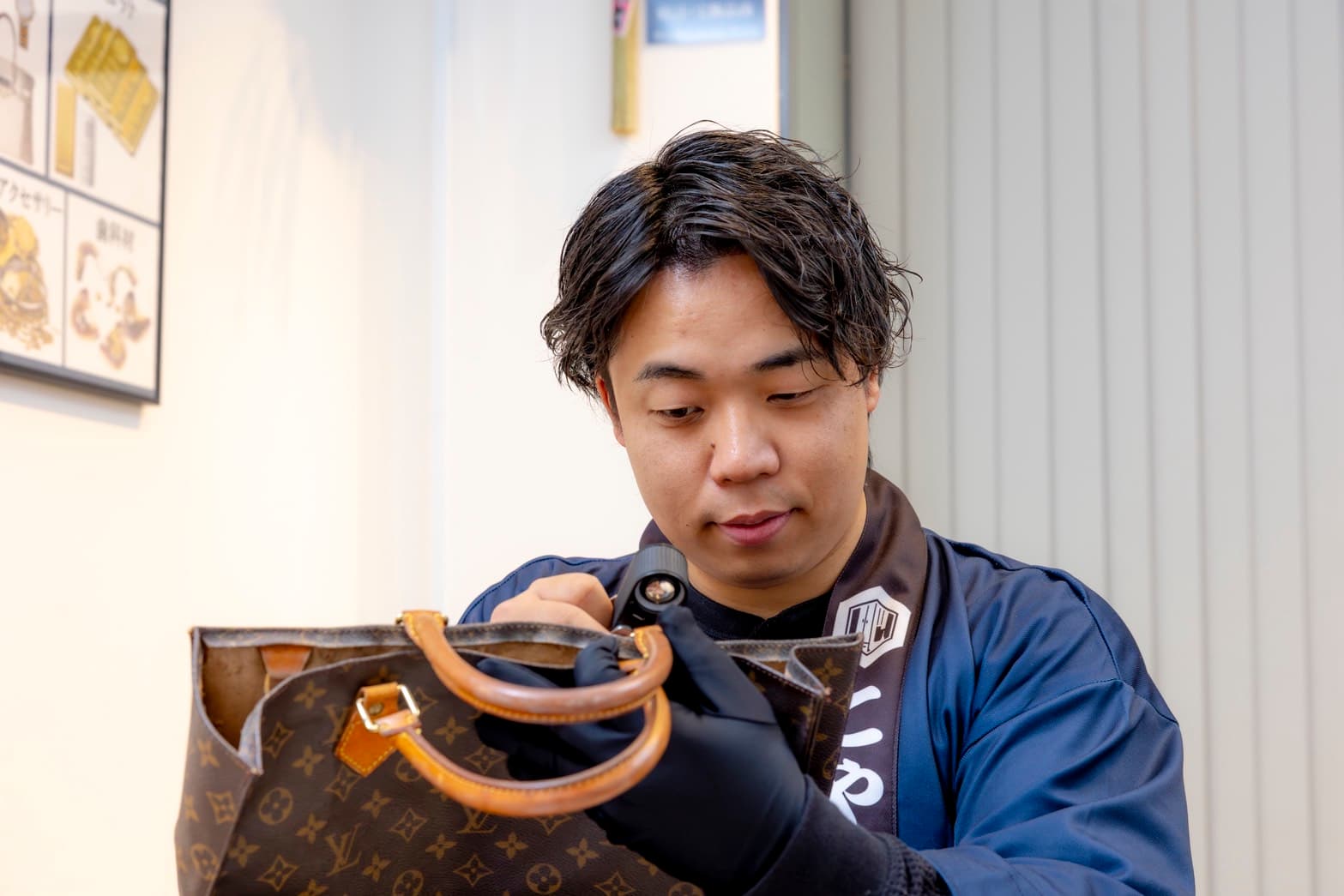 鑑定士がバッグを査定する風景